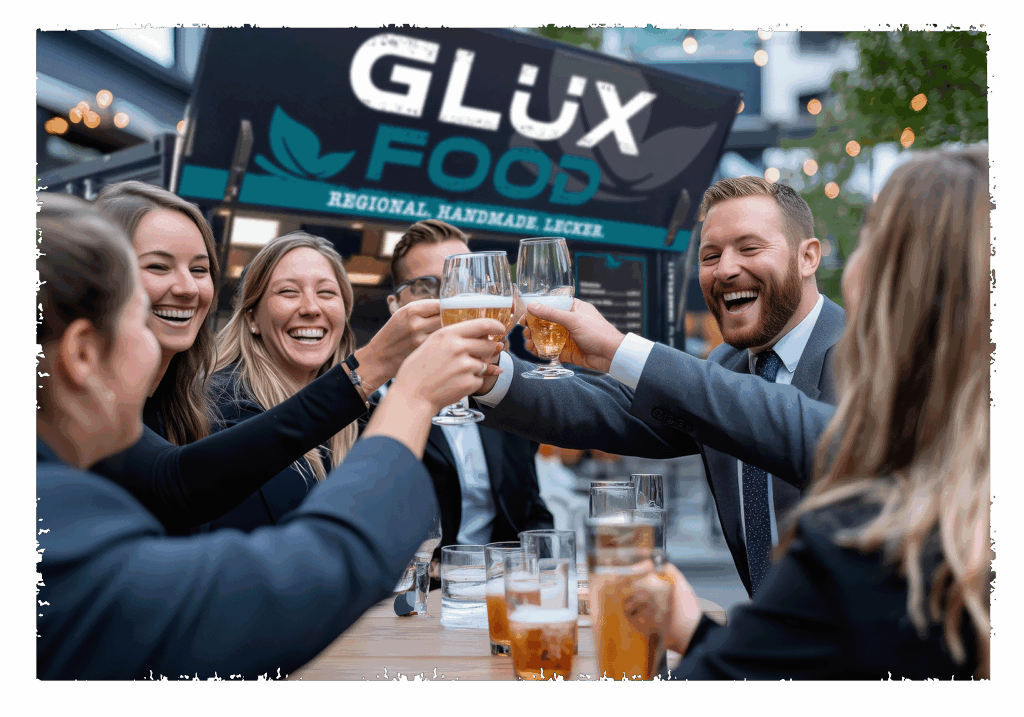 Mitarbeiten stoßen mit Ihren Gläsern an und freuen sich während der Glüx Trailer im Hintergrund zu sehen ist.