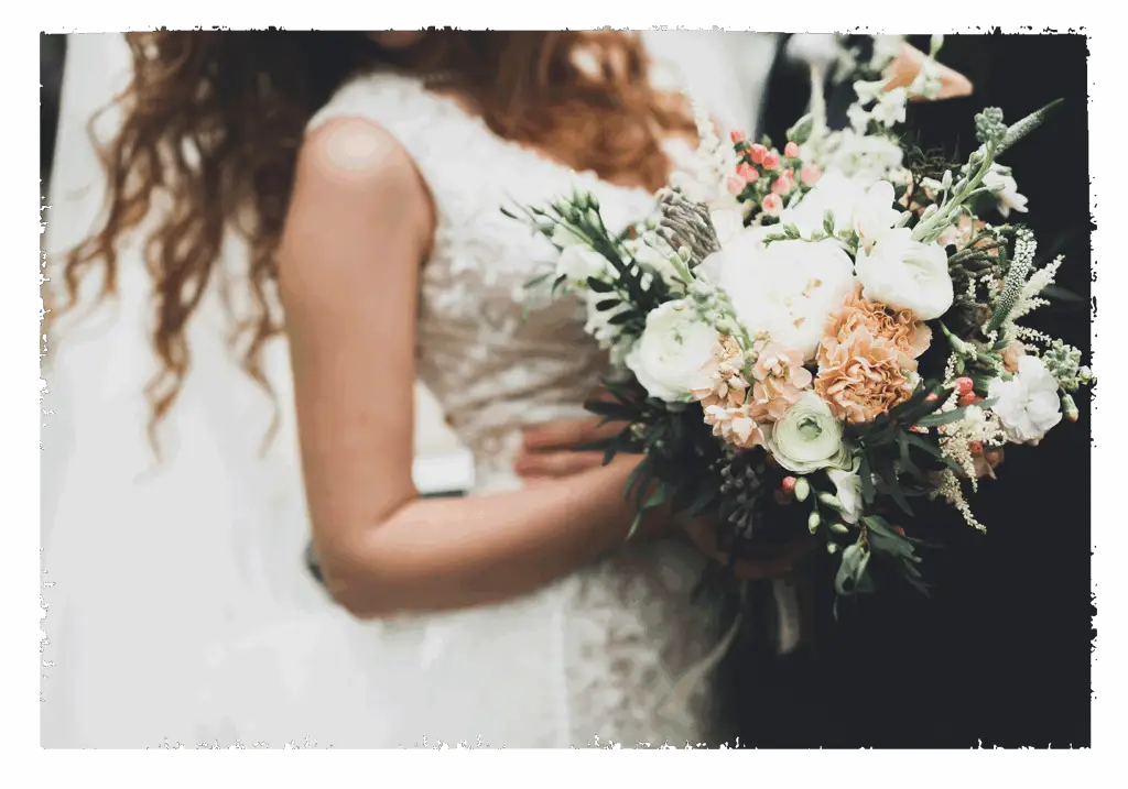 Ein Brautpaar tanzt und der Blumenstrauß ist groß im Bild.